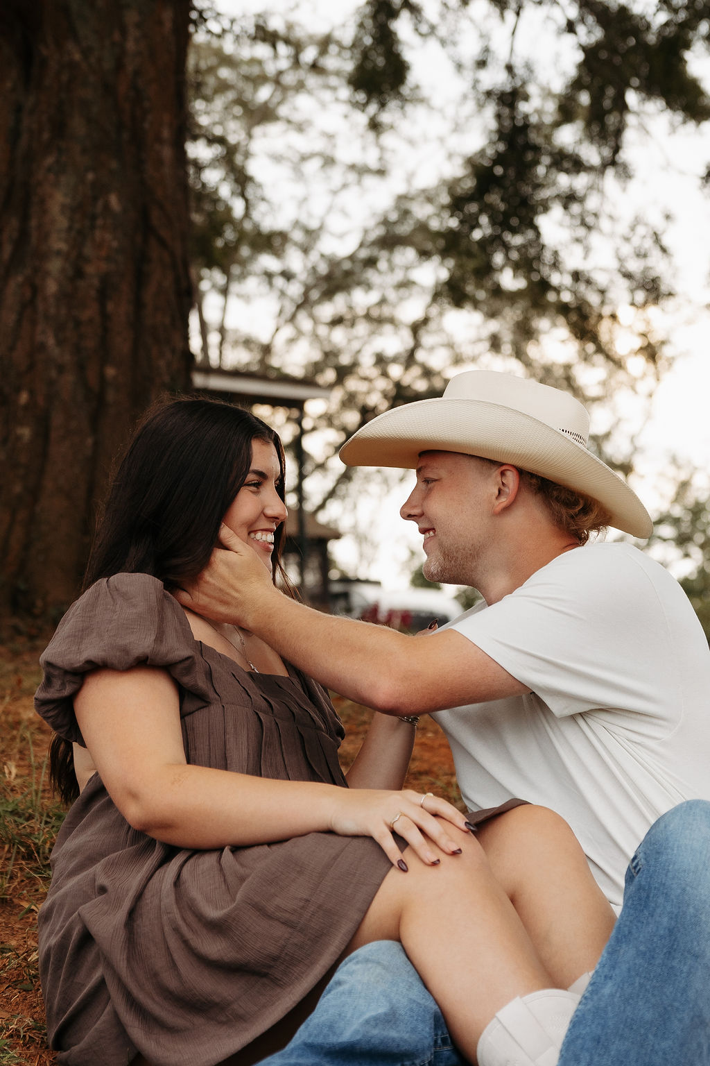 Cody and partner smiling together outdoors among trees
